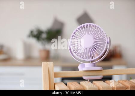 Lilac mini fan on shelf in kitchen, closeup Stock Photo