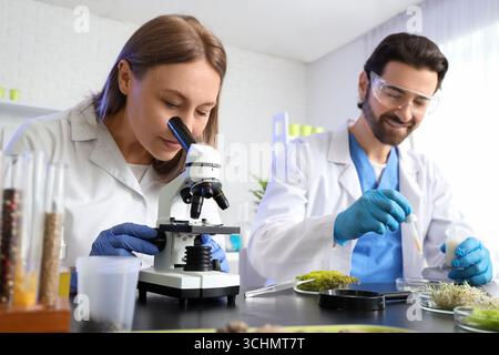 Female agricultural engineer looking through microscope in laboratory Stock Photo
