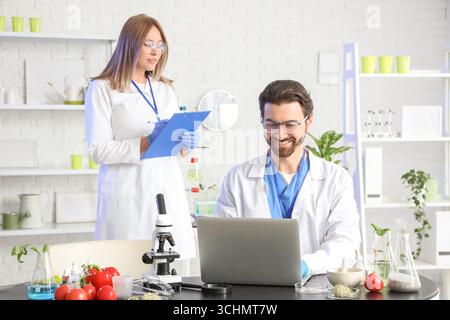 Agricultural engineers working with laptop in laboratory Stock Photo