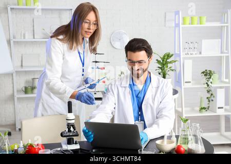 Agricultural engineers working with laptop in laboratory Stock Photo