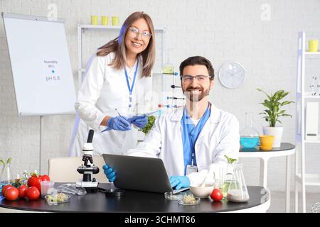 Agricultural engineers working with laptop in laboratory Stock Photo