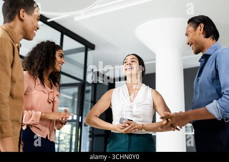 Diverse business team laughing and collaborating in modern office environment Stock Photo