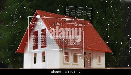 Showing miniature house model sitting on flat plane in garden, with digital panels displaying data Stock Photo