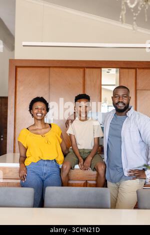 Smiling family of three enjoying quality time together in modern kitchen Stock Photo