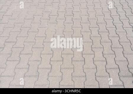 Close-up of interlocking paving stones forming geometric pattern on pedestrian pathway, texture and design background Stock Photo