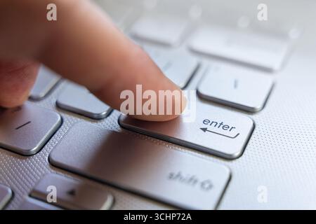 Finger Pressing Enter Key On Laptop Keyboard Close Up Stock Photo