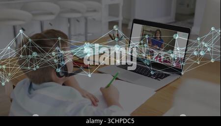 Sitting boy in shirt and headset at kitchen table, learning with laptop and pencils under overlay Stock Photo