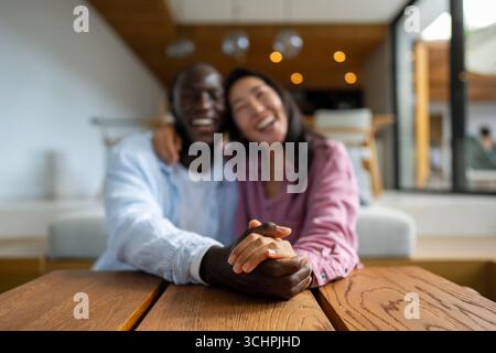 Joyful African-Asian couple embracing their diverse backgrounds, celebrating togetherness, identity Stock Photo