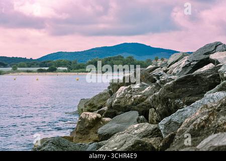 Clear, shallow water over rocks and pebbles near a shoreline.France,Cogoline 26.08.2025. Stock Photo