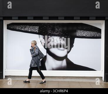 Woman walking using mobile phone, Stratford-upon-Avon, UK Stock Photo