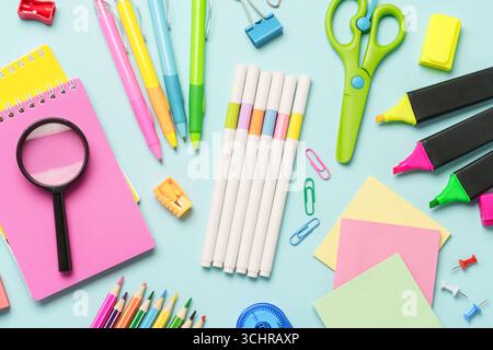 Office stationery on blue background. Top view. Notepad, markers, pens, calculator and others. Stock Photo