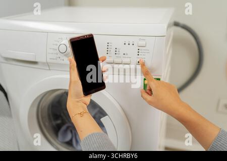 You can now control your washing machine settings conveniently via your smartphone Stock Photo