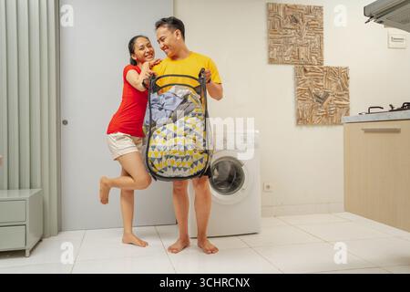 A Joyful Couple Enjoying Doing Laundry Together in the Comfort of Their Home Stock Photo