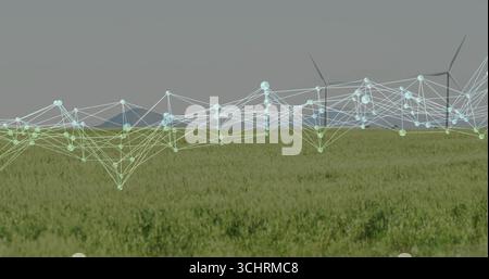 Projecting digital network overlay spanning field to wind turbines on farmland, with glowing nodes Stock Photo
