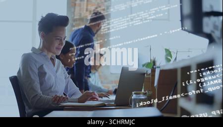 Collaborating professionals coding on laptop and desktop monitor at desk in office, copy space Stock Photo