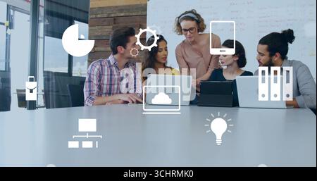 Team of five professionals collaborating in meeting room, with laptops, tablet, digital icons Stock Photo