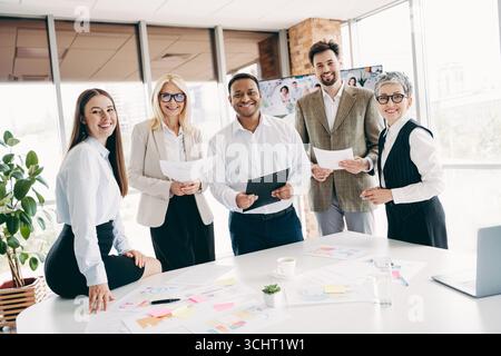 Diverse team of professionals collaborating at a modern office setting, focused on teamwork and productivity. Stock Photo
