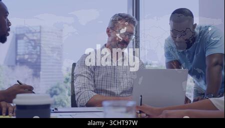 Collaborating colleagues analyzing documents around office desk, with laptop and world map overlay Stock Photo