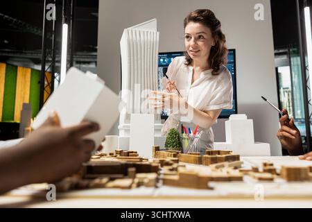 Property developer leads the planning session with 3D models for details and zoning regulations, focusing on site development and infrastructure growth for housing and urban development. Stock Photo