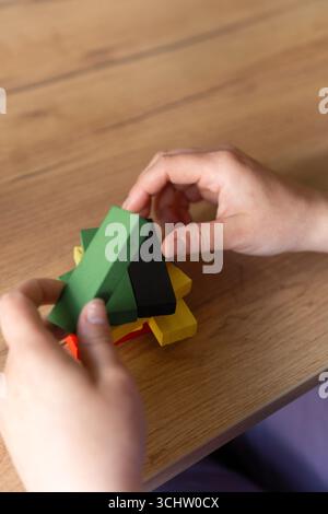 Hands arranging colorful blocks on a wooden table Stock Photo