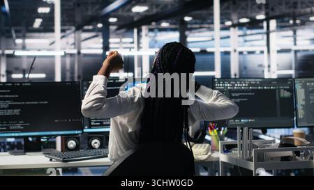 Data center manager checking work done by admins using deep learning to analyze datasets. Server hub supervisor overseeing IT specialists using AI neural networks to recognize data patterns, camera A Stock Photo