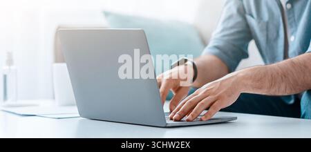 Unrecognizable bearded man working on pc, typing text or programming code on computer keyboard Stock Photo