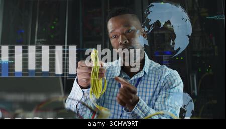 Network engineer connecting yellow cable in front of server racks, with holographic data overlays Stock Photo