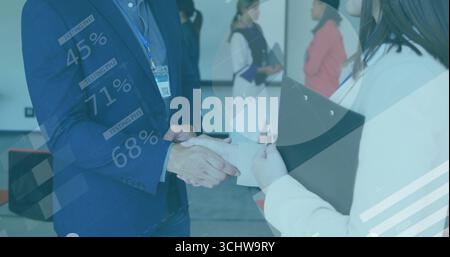 Shaking hands business associates at conference room, with clipboard and data charts overlay Stock Photo