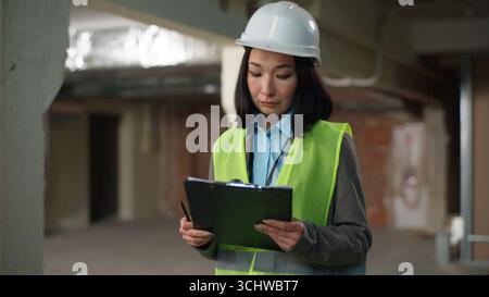 Nervous Asian Korean Japanese woman builder checking documents problem mistake building plan project businesswoman Chinese contractor business female Stock Photo