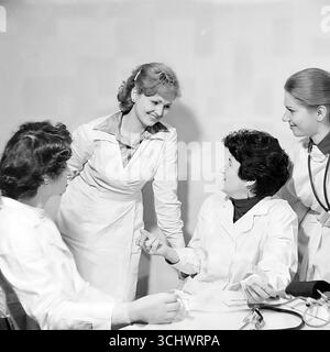 An archival black-and-white photograph taken in a hospital in the Mashmet district of Sloviansk in the 1970s. A group of female doctors or nurses in white coats are collaboratively examining an X-ray film. The frames reflect the daily work, professionalism, and collective approach in Soviet medicine. The photograph is a symbol of the peaceful work of medics in Sloviansk Stock Photo