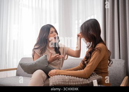 An intense and engaging conversation is happening between two women on a cozy couch Stock Photo