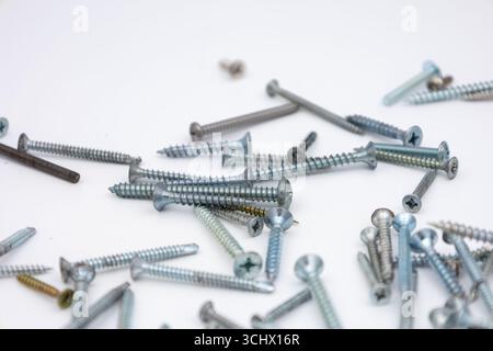 Assorted Metal Screws on White Background for Construction and Repair Stock Photo