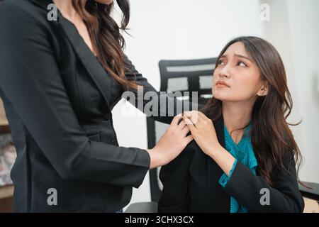 This is a supportive office interaction that occurs between two professional women Stock Photo