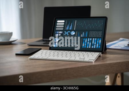 Businessman analyzing financial data and statistics on digital tablet with charts and graphs, concept of analytics, big data, business intelligence, a Stock Photo