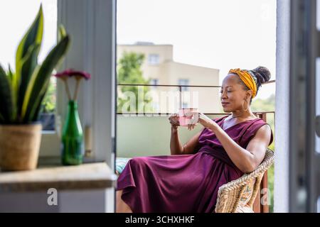 Woman drinking coffee at home balcony Stock Photo