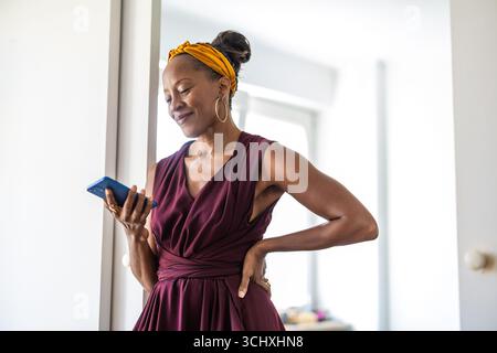 Portrait of smiling businesswoman using mobile phone in office Stock Photo
