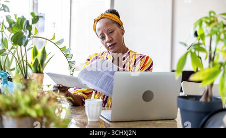 Businesswoman reading documents at her desk in office Stock Photo