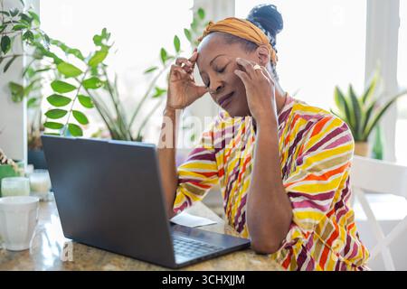 Portrait of stressed woman using laptop at home Stock Photo