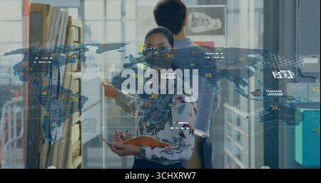 Designer in floral blouse holding notebook examining pinboard sketch in design studio with data map Stock Photo