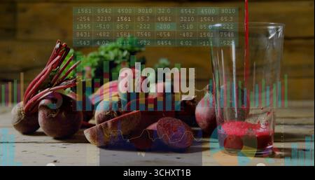 Displaying fresh and sliced beets on rustic table pouring juice into glass with digital overlay Stock Photo