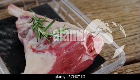 Displaying raw meat cut resting on black tray on wooden counter, with rosemary sprig, digital globe Stock Photo