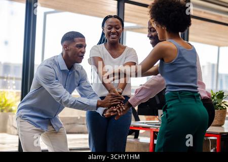 Celebrating success, diverse team collaborating enthusiastically in modern office setting Stock Photo