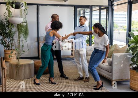 Colleagues greeting each other with enthusiasm in modern office lounge area Stock Photo
