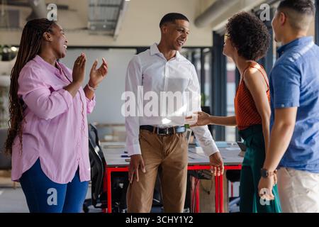 Colleagues in office laughing and chatting during casual team meeting Stock Photo
