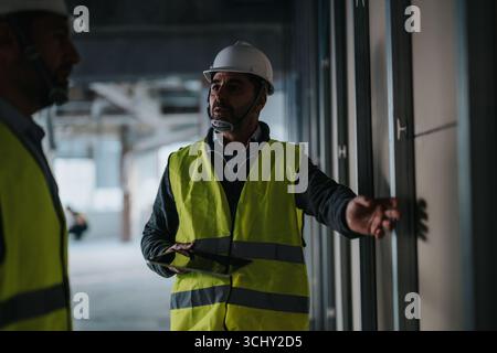 Construction professionals inspecting a job site and collaborating on site developments Stock Photo