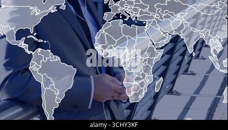 Standing man in dark suit clasping hands on rooftop terrace, with glass railing and map overlay Stock Photo