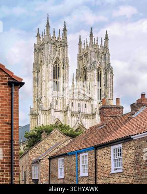 Street view, and looking up, at the historical Minster (church) on a bright sunny morning under a cloudy sky in Beverley, Yorkshire, UK. Stock Photo