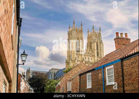 Street view, and looking up, at the historical Minster (church) on a bright sunny morning under a cloudy sky in Beverley, Yorkshire, UK. Stock Photo