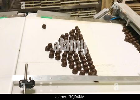 Chocolate candies on the conveyor line at the candy factory Stock Photo