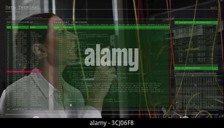 Using smartphone, technician in white shirt analyzing terminal windows by server racks with cables Stock Photo